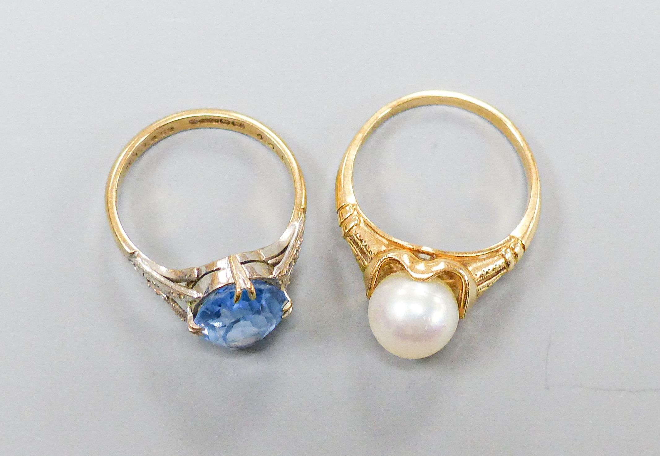 A 14K ring set with a cultured pearl in a fancy mount, size O, gross 4 grams and a 9ct gold dress ring set with an oval blue stone, 3.4 grams.